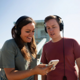 Two individuals listening to a podcast and reacting to the content